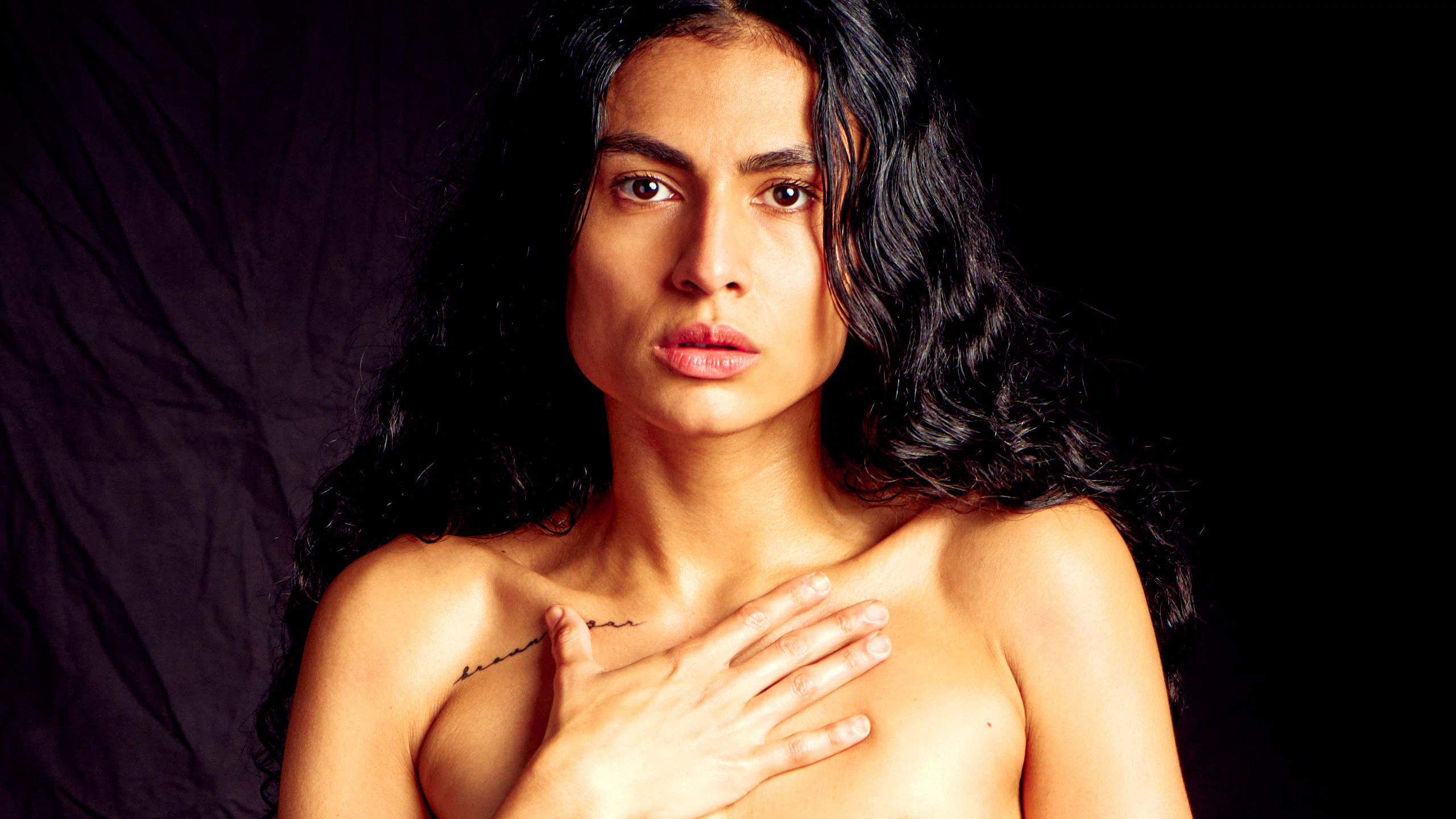 Bold erotic fine art portrait highlighting striking red leather, intimate presence, and expressive gaze