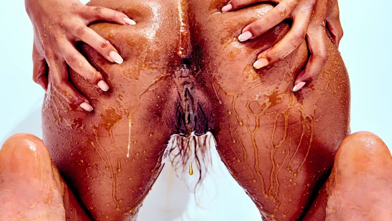 African Beauty nude smearing honey over her tattooed body in Golden Touch